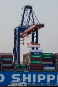 A large cargo container terminal with cranes at the Port of Rotterdam during twilight.